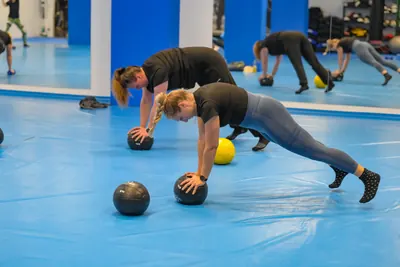 Liegestütze auf Medizinbällen im Zirkeltraining