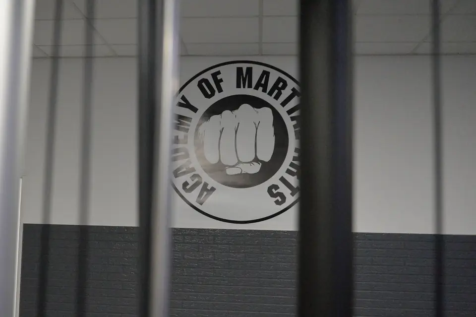 Logo der Academy of Martial Arts an der Hallenwand